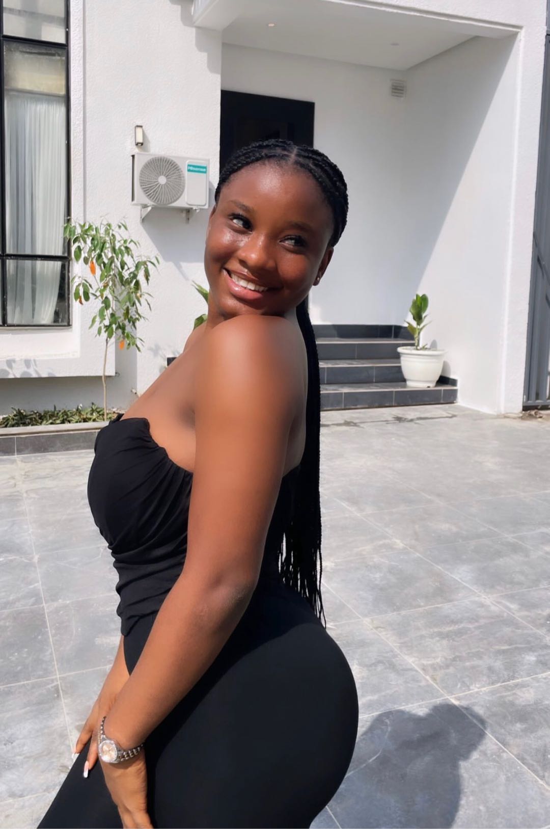 A woman from Nigeria smiling outdoors, using MeetCamChat from her phone’s home screen