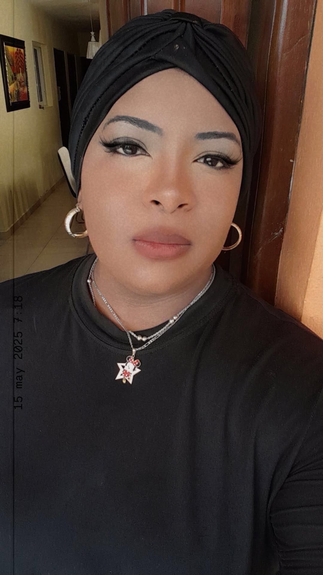 A woman from the Dominican Republic in a black headwrap and gold hoops, one of the girls on MeetCamChat