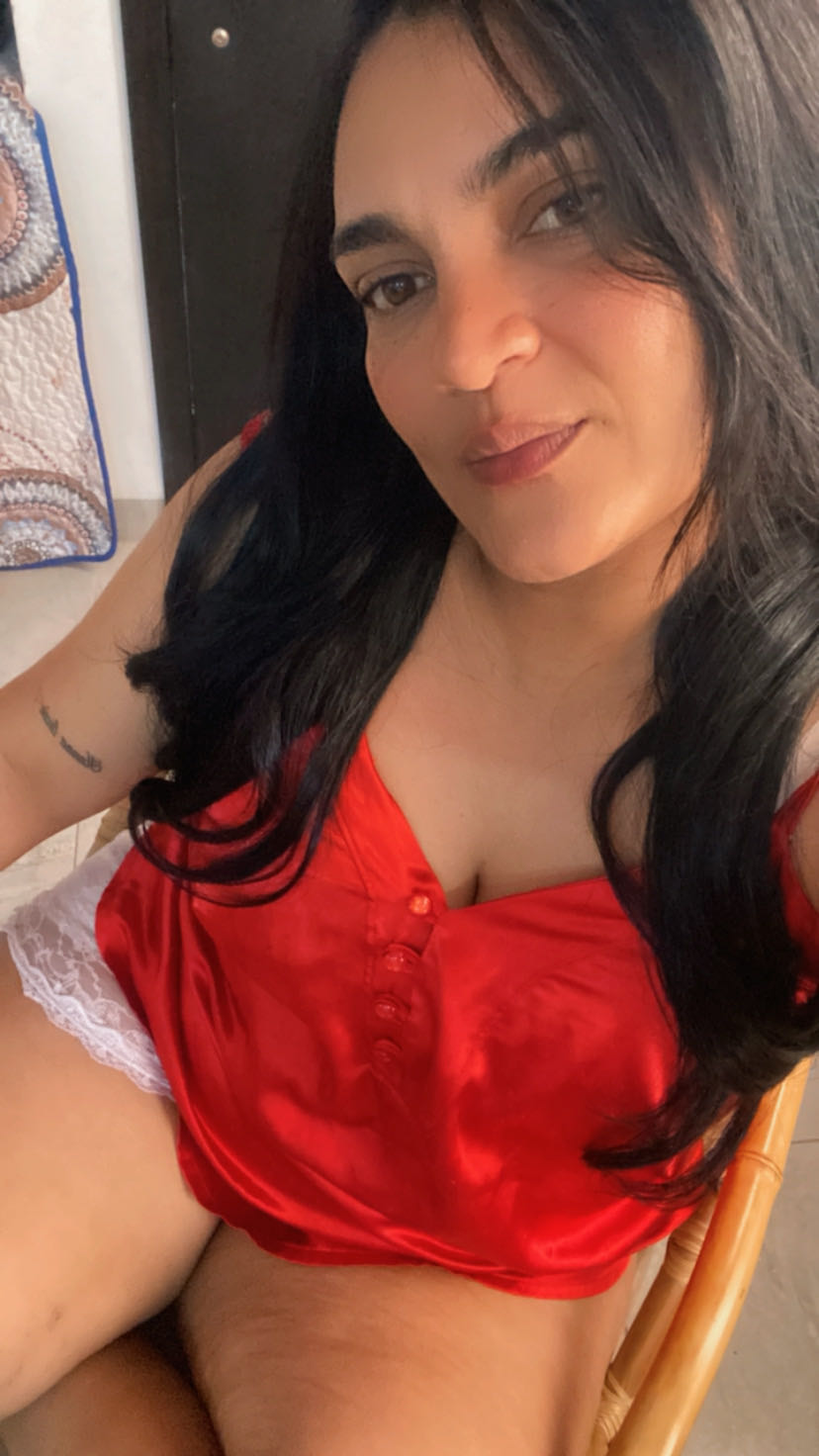 A woman from Colombia in a red top looking into her camera